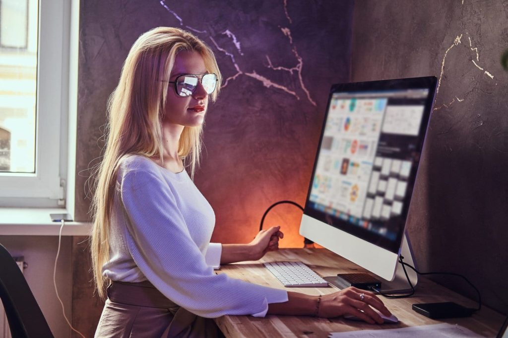 attractive blond girl is studying her modern room using computer scaled 1